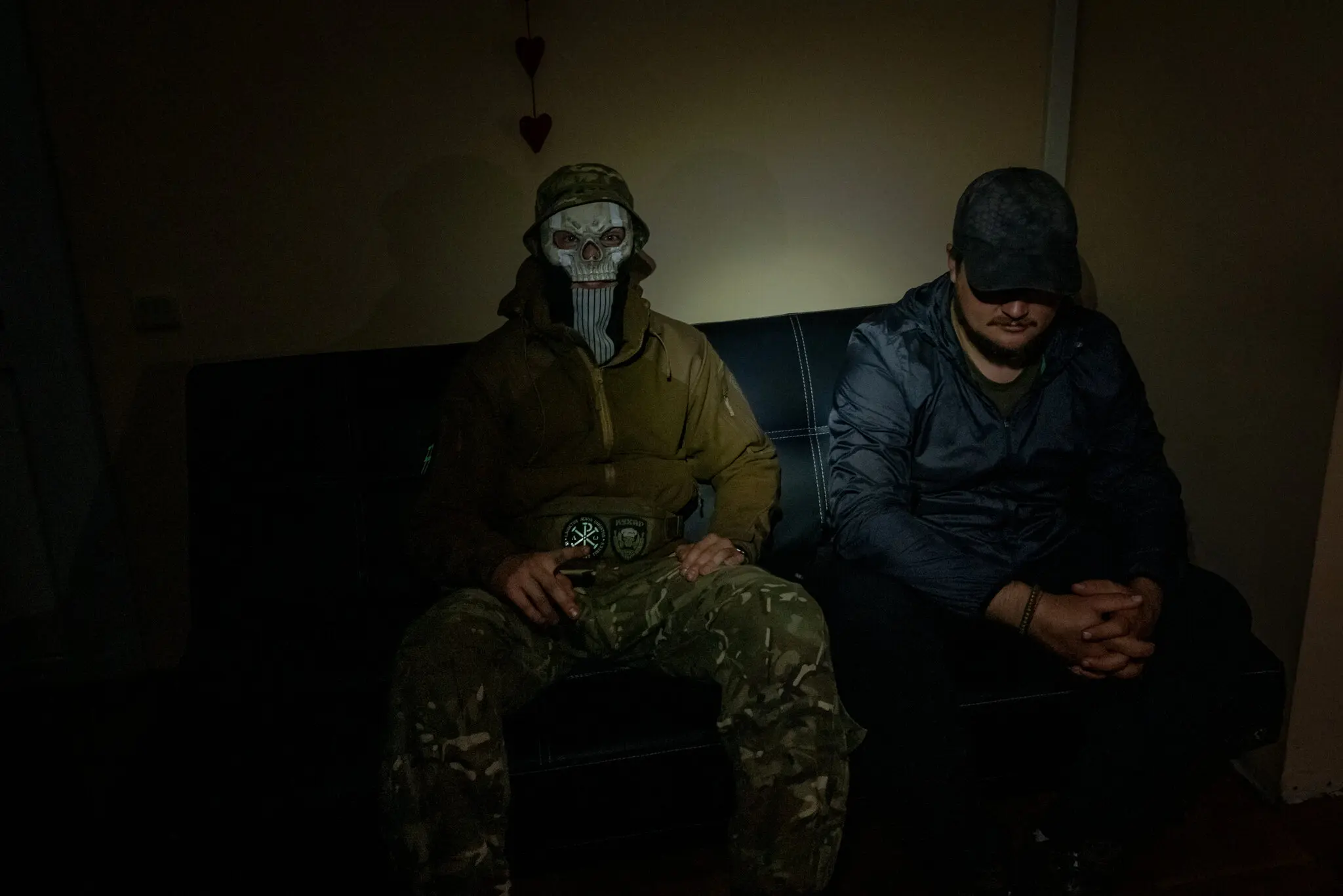 Українські спецназівці, відомі як Кухар, ліворуч, 23 роки, і Аскольд, 38 років, які приховують свої особи, зустрілися, щоб описати рейд на Крим, у голому офісі, який використовувався як безпечний будинок у Києві, столиці України